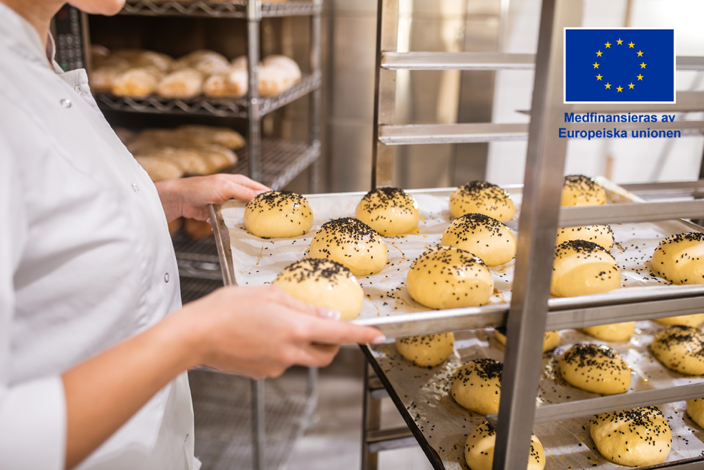 Bakplåt med bröd vid en bageriugn.